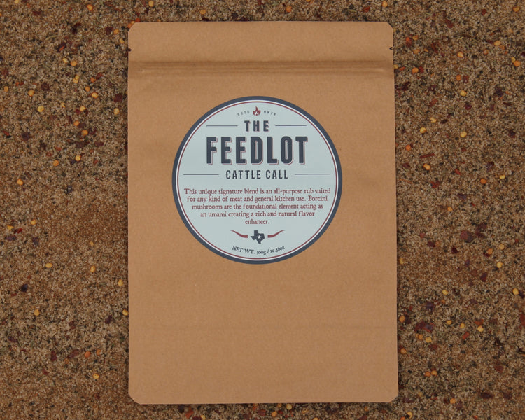 A brown paper package labeled "Cattle Call by The Feedlot" describes an all-purpose rub for grilling and smoking meat. Featuring porcini mushrooms as a natural flavour enhancer, it offers an umami and rich natural flavor. The package is set against a textured background.
