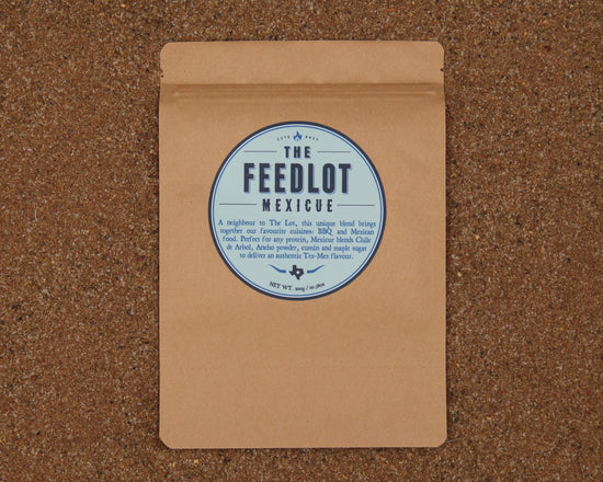 A brown paper package with a circular label that reads "The Feedlot Mexicue." The package is set against a textured, brown background. The label mentions that it contains a unique blend of spices for BBQ and Mexican cuisine, offering an authentic Tex-Mex flavor, weighing 75g.
